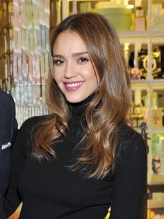 a woman standing in front of a store window with her hands on her hips and smiling at the camera