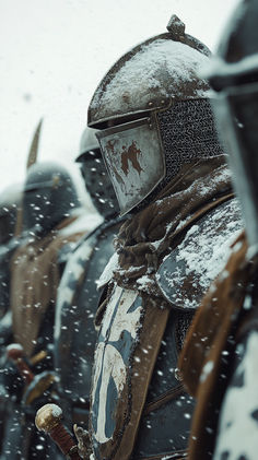 a group of men in armor standing next to each other on a snow covered field