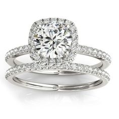 an engagement ring set with a cushion cut diamond in the center and two rows of pave