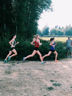 three women running in a race on the grass