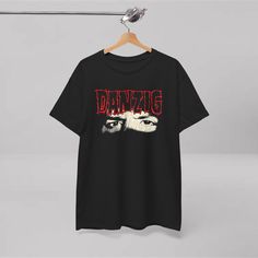 a black t - shirt hanging on a clothes line with the words dancing printed on it