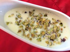 a white bowl filled with food on top of a red cloth