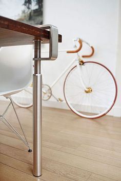 a white chair sitting under a table next to a bicycle