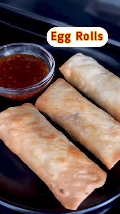 egg rolls on a plate with dipping sauce