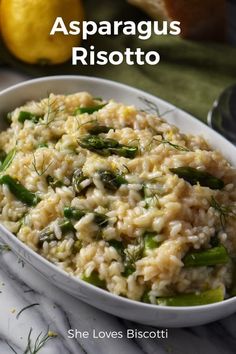 a white bowl filled with rice and asparagus on top of a marble counter