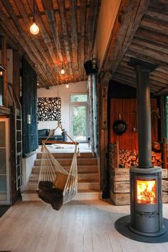 a hammock hanging from the ceiling next to a stove in a living room