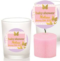 a pink candle next to a glass with a baby shower sticker on it