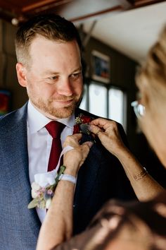 a man in a suit fixing another mans tie