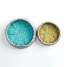 two bowls sitting next to each other on top of a white surface with blue and yellow colors