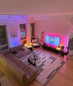 a living room filled with furniture and a flat screen tv sitting on top of a wooden floor