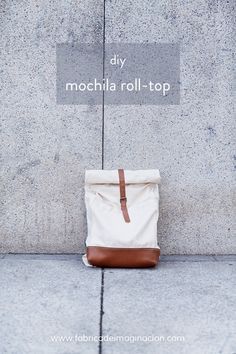 a canvas bag sitting on the sidewalk with text overlay that reads diy mochila roll - top