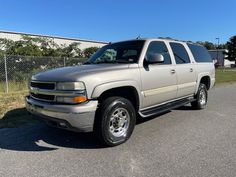 a silver truck is parked on the street in front of a fenced off area