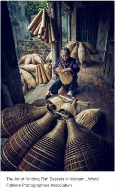 a woman sitting on the ground with baskets in front of her