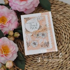 a thank you card sitting on top of a wicker basket next to pink flowers