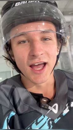 a young man wearing a hockey uniform and helmet