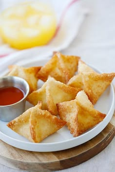 some food is sitting on a plate with dipping sauce in the bowl next to it