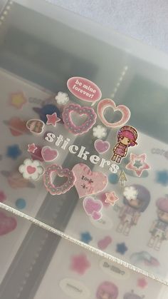 there are many stickers on the glass window in front of this display case that is decorated with hearts, stars and other things