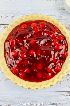 a cherry pie sitting on top of a wooden table