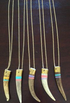 four necklaces with different types of knives hanging from them