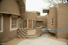 an adobe building with stone steps and windows