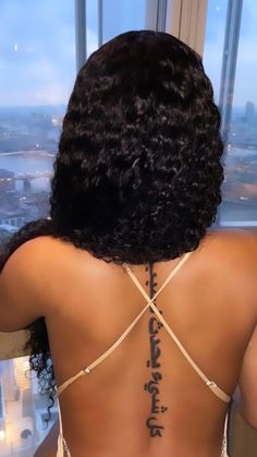 the back of a woman's body with tattoos on it