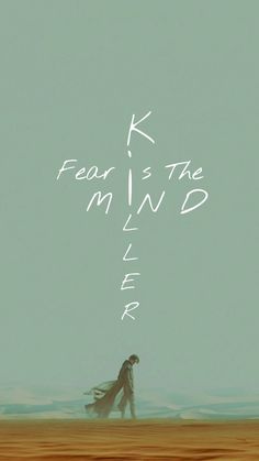 a man walking across a sandy beach under a sky filled with white writing that reads fear is the mind killer