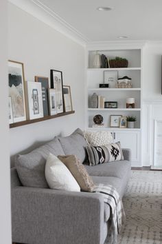 a living room filled with furniture and pictures on the wall