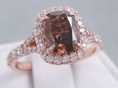 a fancy ring with a large brown diamond surrounded by white and rose gold pave