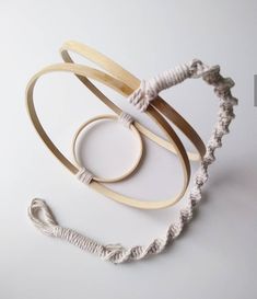 three pieces of wood and rope on a white surface with the string attached to it