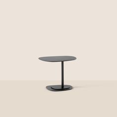 a black table with a round top and two legs, on a white surface in front of