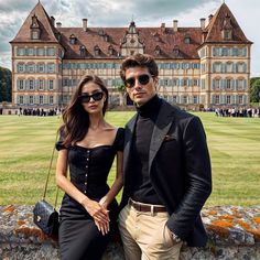 a man and woman standing next to each other in front of a large building