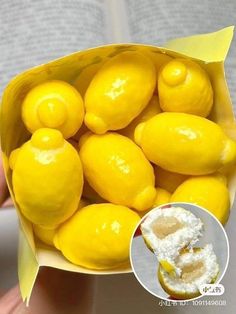 a person holding a paper bag filled with lemons and powdered sugar on top