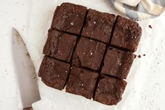 chocolate brownies cut into squares with a knife next to them