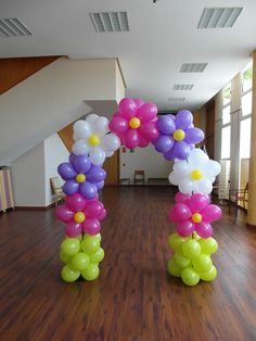 balloons are arranged in the shape of flowers on a wooden floor inside an office building