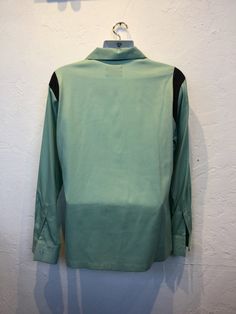 "1950s vintage reproduction Hollywood Rogue two tone mint green and black shirt The shirt has a two tone design with mint green and contrasting black on shoulders and neckline. The garment has a loop collar, five button down front, one patch pocket and long sleeves. The label reads \"Hollywood Rogue\" and the shirt is in new unworn condition. As with all clothes made by \"Hollywood Rogue\" this shirt was made in an original 1950's design and is only available in very limited numbers. Made in Cal Retro Green Collared Shirt, Retro Black Tops For Work, Retro Black Workwear Shirt, Retro Black Shirt For Work, Retro Green Button-up Top, Vintage Green Shirt For Work, Vintage Green Shirt For Workwear, 1950s Design, Usa Shirt