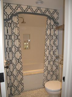 an image of a bathroom setting with shower curtain and toilet in the corner, next to bathtub