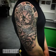 a man with a clock and roses tattoo on his arm