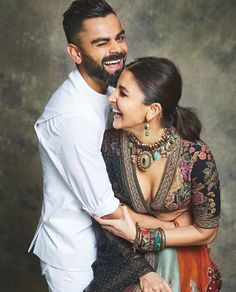 a man and woman hugging each other in front of a gray background with the caption's name on it