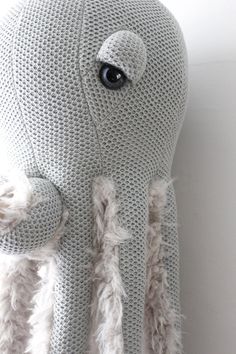 an octopus stuffed animal sitting on top of a white wall