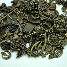 a pile of antique metal items on a white surface with scissors, keys and other things