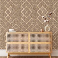 a white vase sitting on top of a wooden dresser next to a wallpapered wall