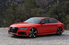 an orange car parked on top of a gravel field