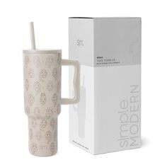 a white cup with a straw in it next to a cardboard box and the packaging