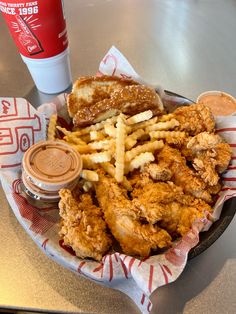 fried chicken and french fries on a plate next to a cup of ketchup