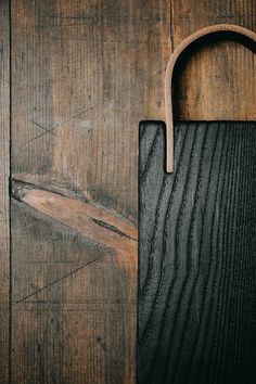 a cutting board with a wooden handle on it's side against a wood background