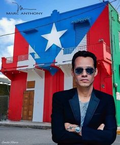 a man wearing sunglasses standing in front of a red, white and blue building with stars on it