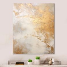 an abstract painting in gold and white on a wall