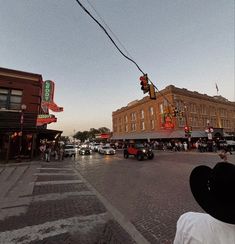 a city street filled with lots of traffic next to tall buildings and people walking on the sidewalk