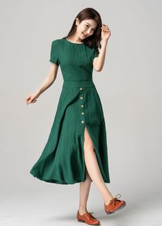 "Add a touch of retro elegance to your wardrobe with this beautiful 1950s green linen short-sleeved dress. The dress features button decorations that give it a classic look, while the flattering cut ensures that you look your best. The dress can be dressed up with heels and accessories for a formal event or dressed down with flats for a more casual look. The green color is a beautiful shade that will complement any skin tone. DETAILS * 50% linen, 50% cotton blend * Two side seam deep pockets * B Dark Green Knee-length Midi Dress For Summer, Chic Green Linen Midi Dress, Chic Green Midi Linen Dress, Elegant Green Midi Vintage Dress, Green A-line Dress With Buttons, Elegant Green Linen Dress For Spring, Green A-line Vintage Midi Dress, Green Fitted Linen Dress, Elegant Fitted Green Linen Dress