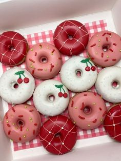 a box filled with donuts covered in pink frosting and sprinkles